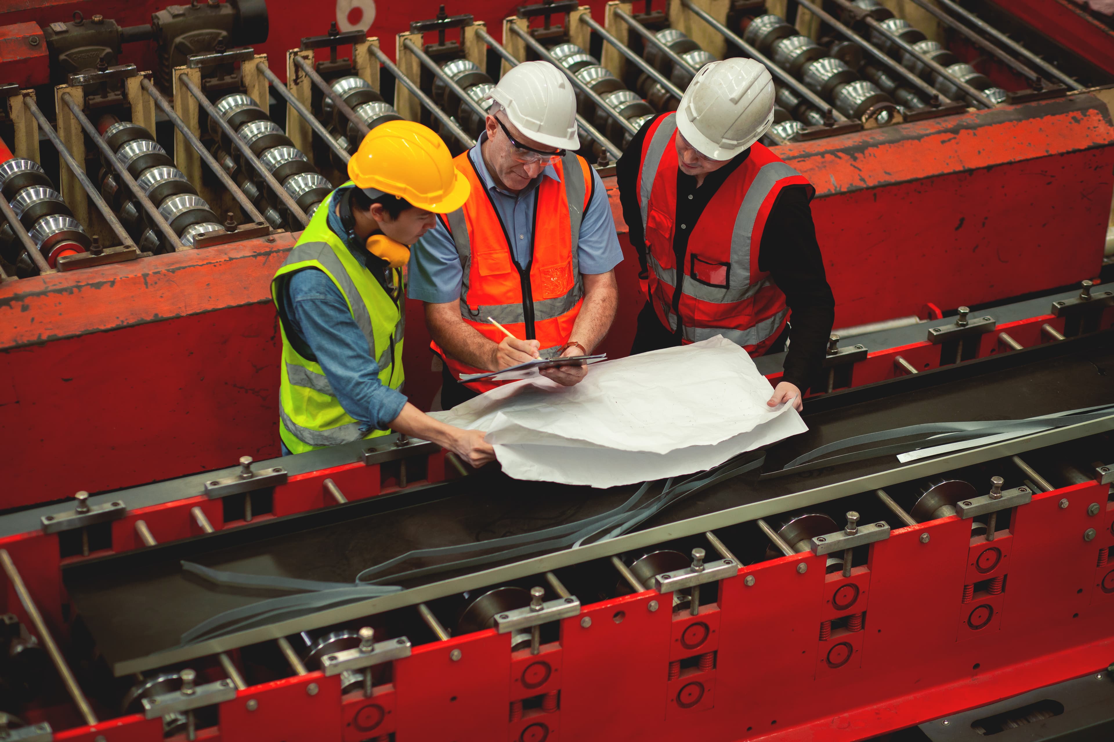 Overhead view of engineers collaborating over technical drawings at a shared workstation